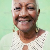 Portrait of senior black woman smiling at camera on green background-02
