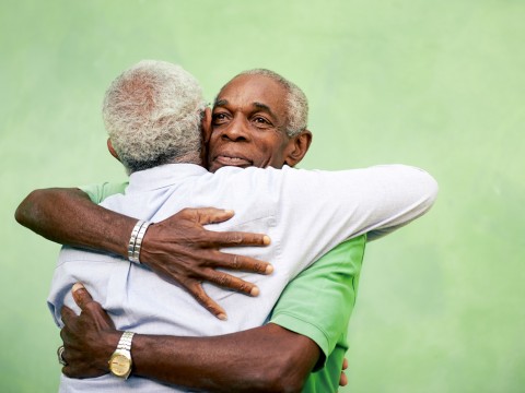 Old friends, two senior african american men meeting and hugging